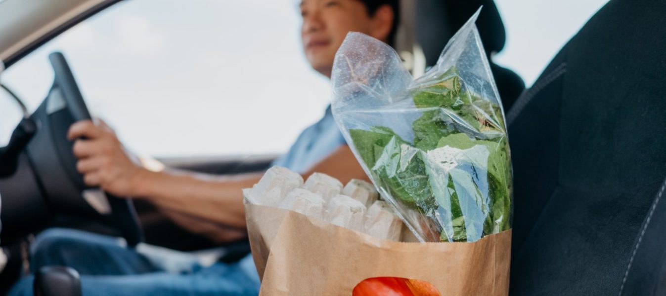 Asian male driver delivering groceries to customer