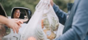asian chinese mid adult woman Mature woman picking her to go order from her car at a Curbside pickup