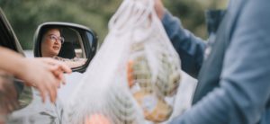 asian chinese mid adult woman Mature woman picking her to go order from her car at a Curbside pickup